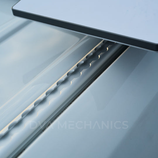 Close-up of a crossbar mounting plate attached to the LoadSpan L-track channel on a Mercedes Sprinter roof